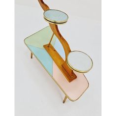 a multicolored wooden stand with two mirrors on it's top and bottom