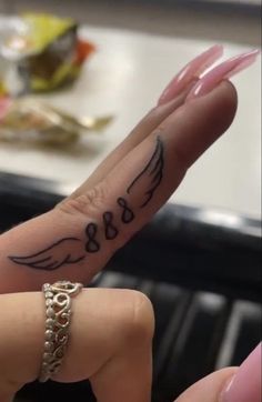 a woman's hand with a tattoo on it that says love and an angel wing