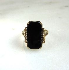 This is a vintage 10K yellow gold black onyx gemstone ring.  The onyx measures 18mm long x 9mm wide.  It rattles a tad in the setting, but is secure.  The band is sized at a 7.  Total weight of the ring is 4.2 grams. The band is stamped 14K & hallmarked inside. This is a vintage, previously owned ring.  Therefore, light wear can be expected.  There is no visible damage. Onyx Gemstone, Rattles, Onyx Ring, Gemstone Ring, Rings Statement, Black Onyx, Gold Black, Statement Rings, Onyx