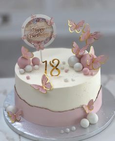 a birthday cake decorated with pink and gold butterflies