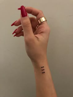 a woman's hand with a small tattoo on her wrist