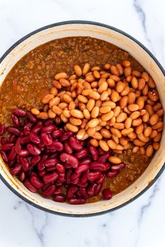 beans and chili in a pot on top of a marble countertop, ready to be cooked