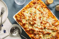 a casserole dish with meat and cheese in it on a blue table cloth