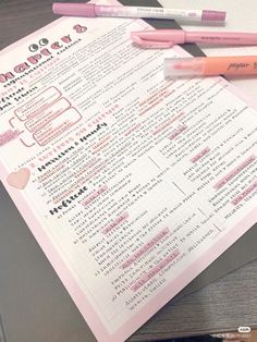 two pens are sitting on top of a pink and white checkered paper with writing instructions