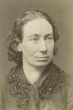 an old black and white photo of a woman with curly hair wearing a collared shirt