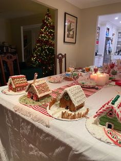 a table with gingerbread houses and candles on it