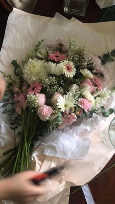 a person cutting flowers with scissors on a table