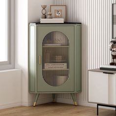 a green cabinet sitting in the corner of a living room next to a white wall