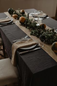 the table is set with black linens and silverware