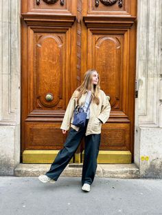 a woman standing in front of a wooden door