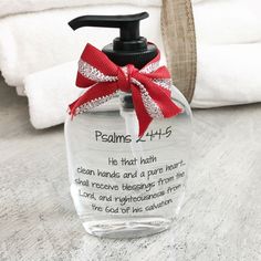 a hand soap dispenser with a red ribbon on it sitting on a table