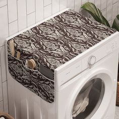 a white washer sitting next to a dryer in a room with tiled walls