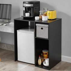 a small desk with a computer and coffee maker