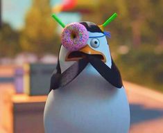 a penguin with a doughnut in its mouth and wearing a donut on it's head