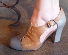 a woman's foot wearing high heeled shoes with an iron bench in the background