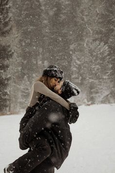 a woman walking through the snow carrying a dog on her back