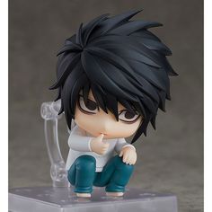 an anime figurine sitting on top of a plastic stand with his finger in his mouth