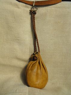 a brown leather purse hanging from a belt