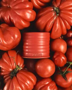 several tomatoes and some red plastic cups with the word love written on them, surrounded by tomato's