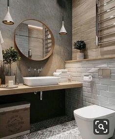 a bathroom with a toilet, sink and mirror on the wall next to each other