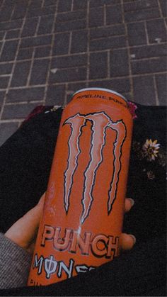 a can of monster energy drink in someone's hand