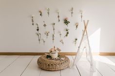 a white room with flowers on the wall and a teepee tent in the corner