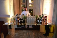 a man standing behind a bar filled with liquor bottles