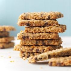 a stack of cookies sitting on top of a white table next to a pile of oatmeal