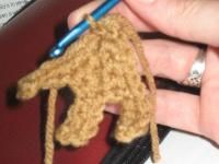 a crocheted giraffe keychain being held by someone's hand