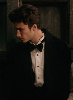 a man in a tuxedo and bow tie looking at something off to the side