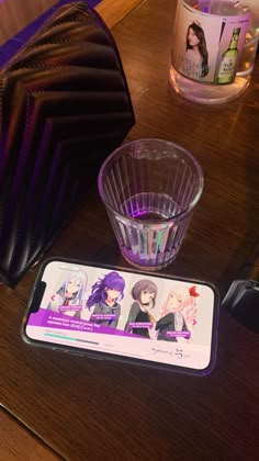 a wooden table topped with a plastic cup filled with liquid next to a card board