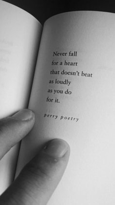 a person holding an open book with the words never fall for a heart that doesn't beat as loudly as you do for it