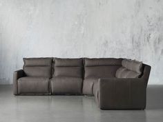 a grey couch sitting in front of a white wall