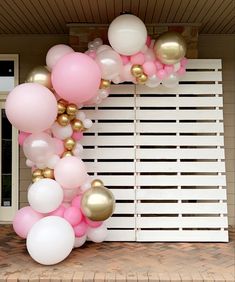 the balloon arch is decorated with pink, white and gold balloons