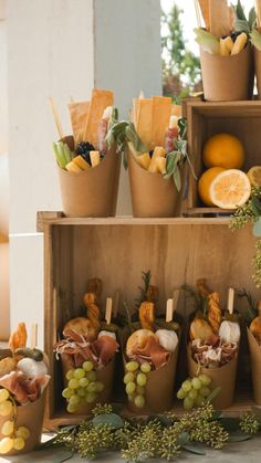 there are many fruits and vegetables on display in the wooden box, including oranges