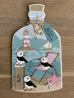 a bottle with some birds on it and a lighthouse in the background that says happy birthday