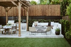 an outdoor living area with white furniture and wooden fenced in areas around the patio