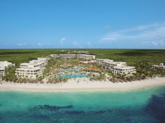 an aerial view of the resort and its surrounding grounds, with blue water in the foreground