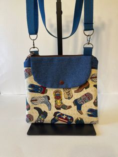 Hey there from sun-kissed Tucson! Debbie here 🌵. In a world of endless choices, isn't it wonderful when one accessory can wear so many hats?  Does the sane "watch my bag" sound familiar, well not anymore.  This zippered 11 x 10 accompanied by a generous front snap pocket crossbody bag will go everywhere you go, rather at an event, line dancing or whatever dancing you're into, it fits snug against your body.  And style? Oh, it's sewn right in! Choose from an array of patterns, each echoing a different rhythm, a different story, a different you. Step out with confidence, and let every day be a statement. Debbie 💕 Casual Adjustable Shoulder Bag For Daily Use, Adjustable Canvas Bags For Everyday Use, Adjustable Multicolor Shoulder Bag For Travel, Multicolor Adjustable Shoulder Bag For Travel, Casual Adjustable Canvas Bags, Casual Blue Adjustable Bag, Casual Blue Adjustable Bags, Casual Handmade Bag With Adjustable Strap, Casual Handmade Bags With Adjustable Strap