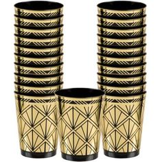 a stack of gold and black vases sitting next to each other on a white background