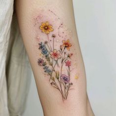 a woman's arm with flowers painted on it and stars in the sky above