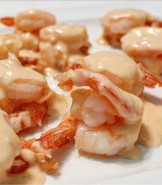 some shrimp is covered in sauce on a white plate with the words grand marnier shrimp