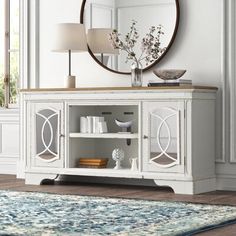 a living room with a large mirror on the wall and a rug in front of it