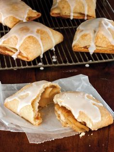 pastries with icing sitting on top of a cooling rack