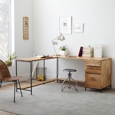 a home office area with desk, chair and bookshelf on the floor in front of a window