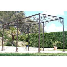 an iron gazebo in the middle of a garden with potted plants next to it