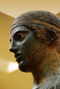 a close up of a statue of a man wearing a headdress