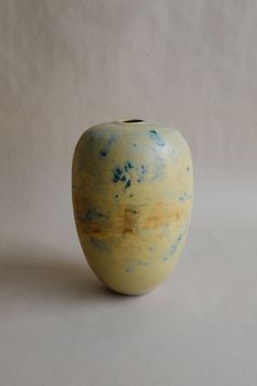 a yellow and blue vase sitting on top of a table