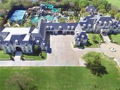 an aerial view of a large mansion in the middle of a green area with water slides