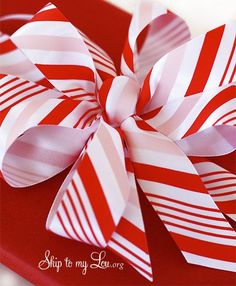 a red and white striped bow on top of a red box with the words skip to my love